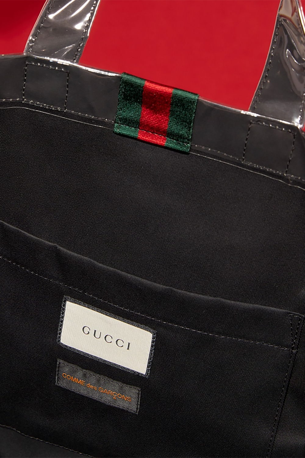 在CdG的白色標誌上飾有Gucci標誌性的垂直「綠、紅、綠」條紋