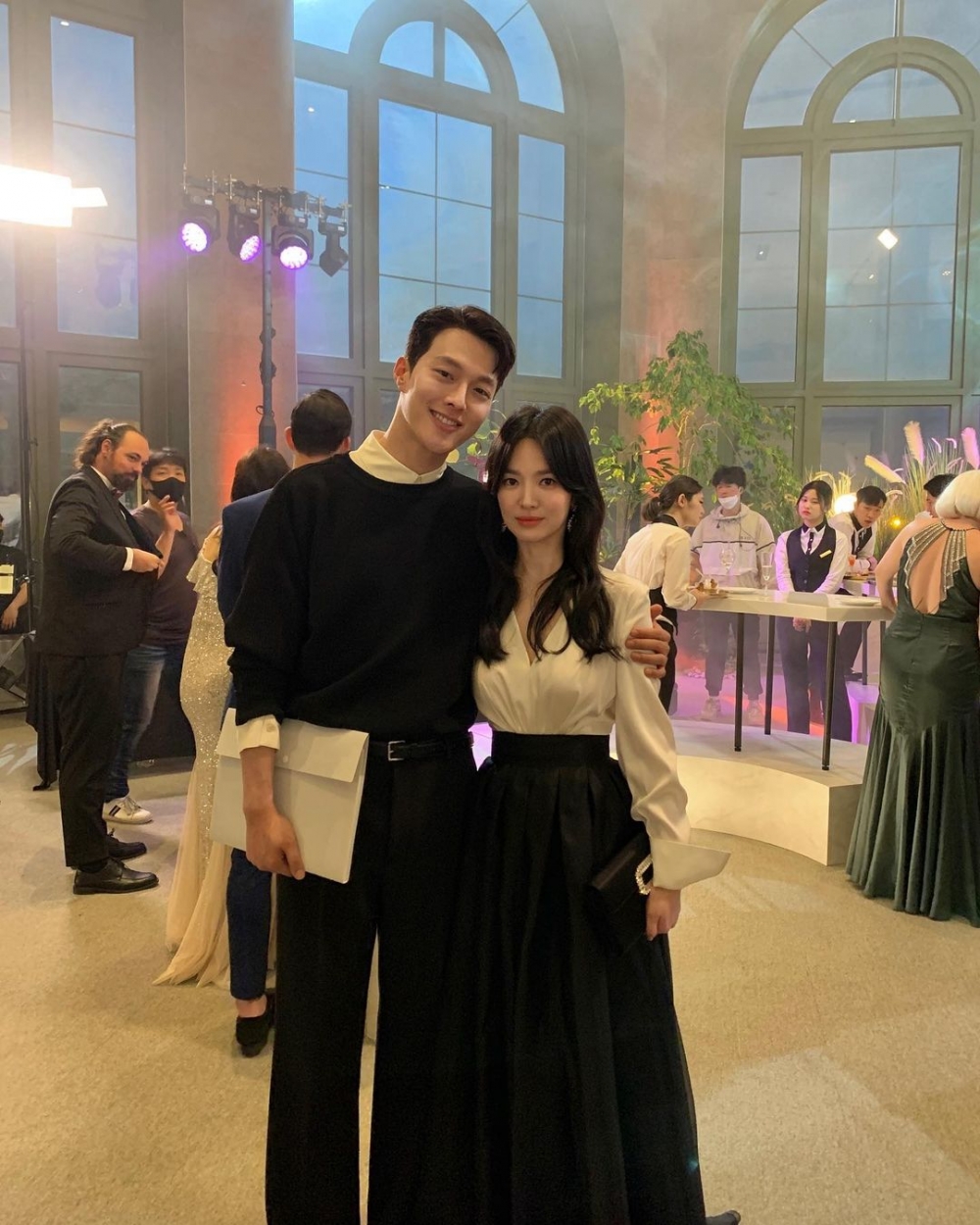 身穿黑色長裙,搭配白色綢緞V領上衣也非常優雅迷人。