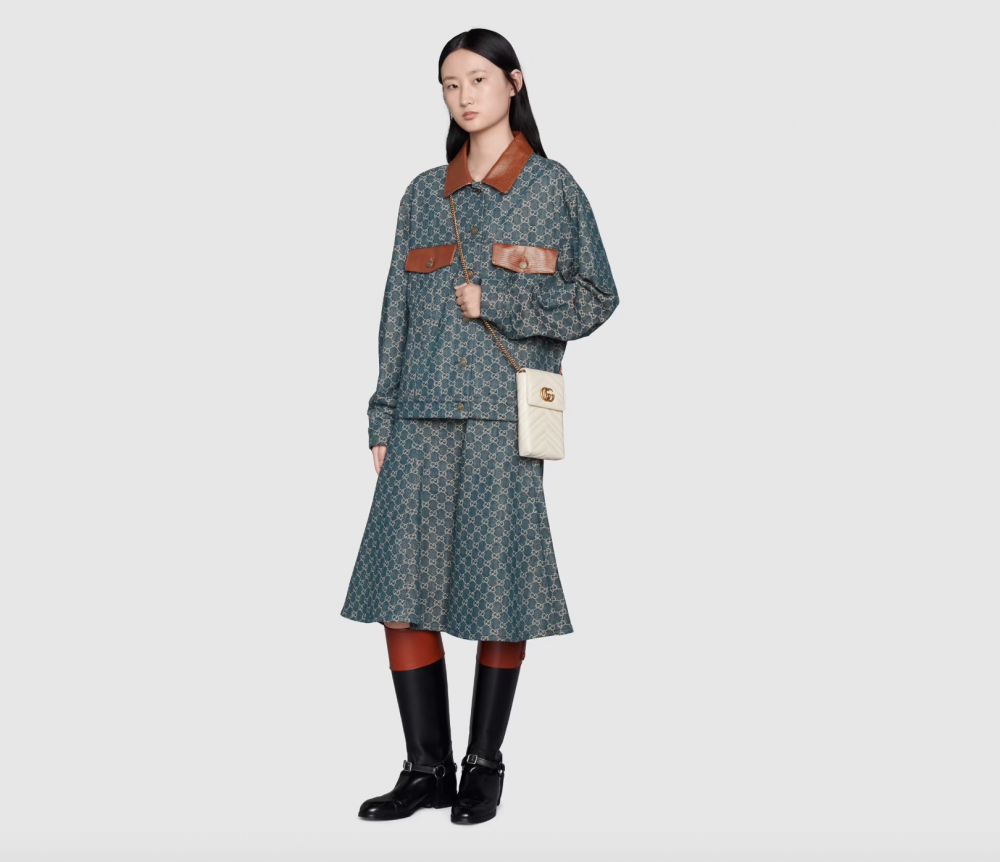 白色的 Gucci 手機包搭配金色的Logo展現高貴氣質。