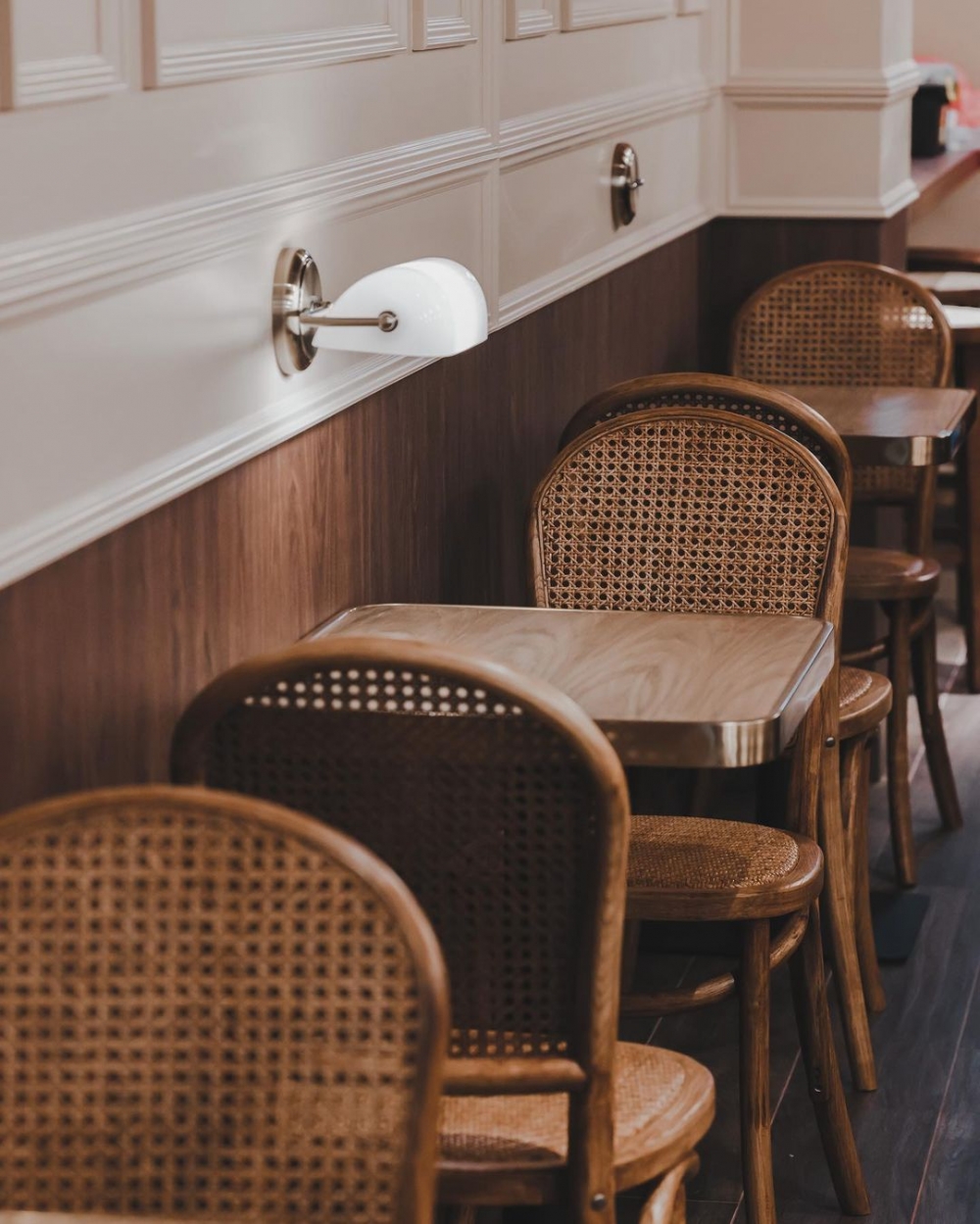 擺放木質、編織質感的桌椅以及典藏銀行燈Bankers Lamp。