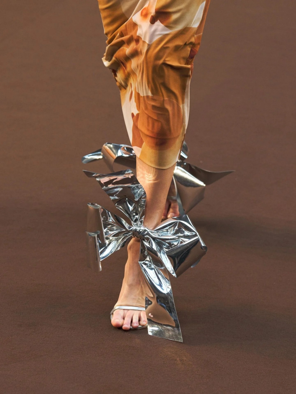 以閃爍光芒般的銀色蝴蝶結呈現的高跟鞋。