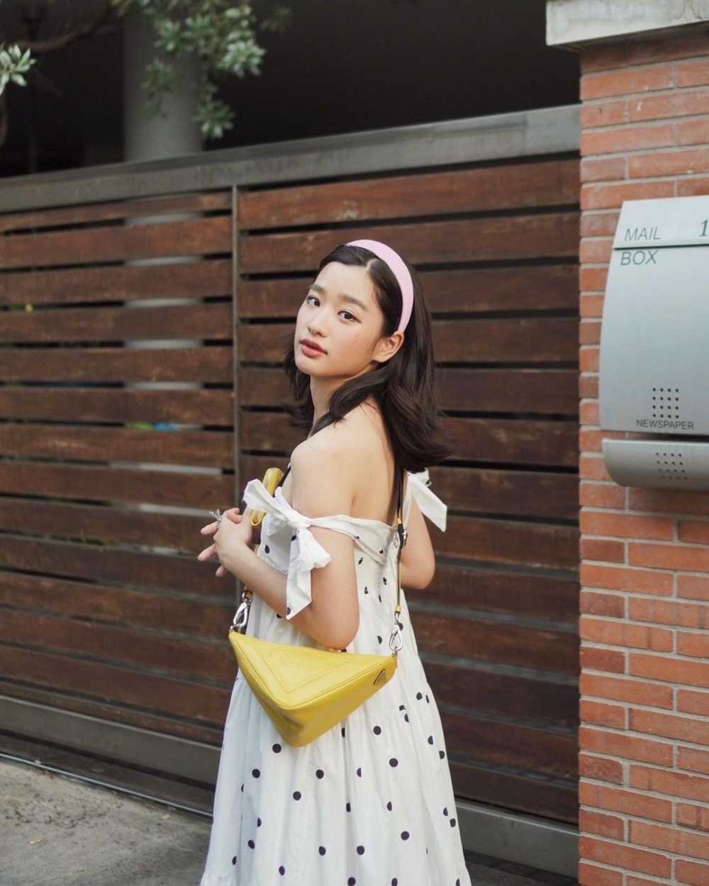甜美的洋裝搭配Prada手袋。