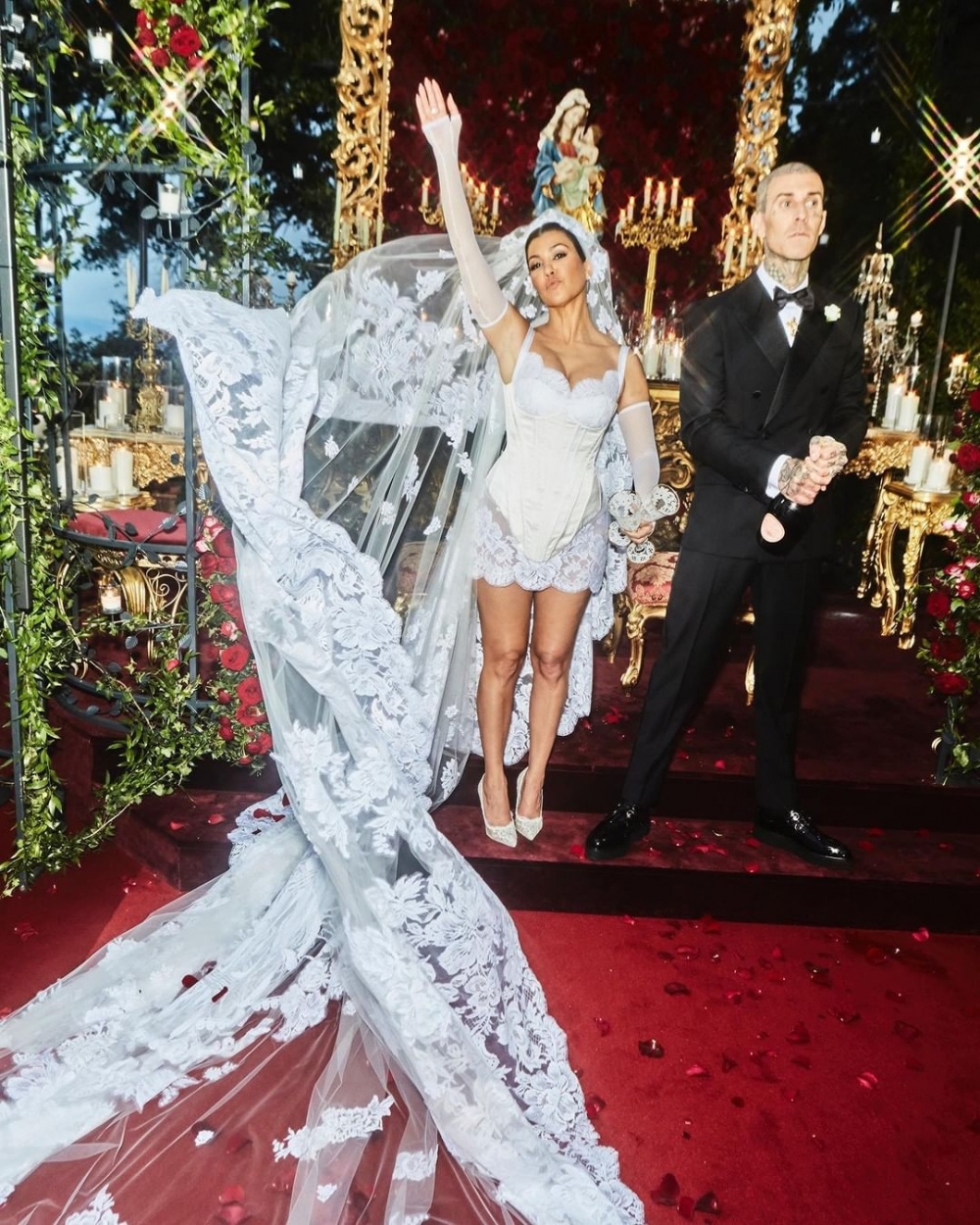 Kourtney Kardashian穿著Dolce & Gabbana為她訂製的蕾絲緞面緊身迷你連衣裙。