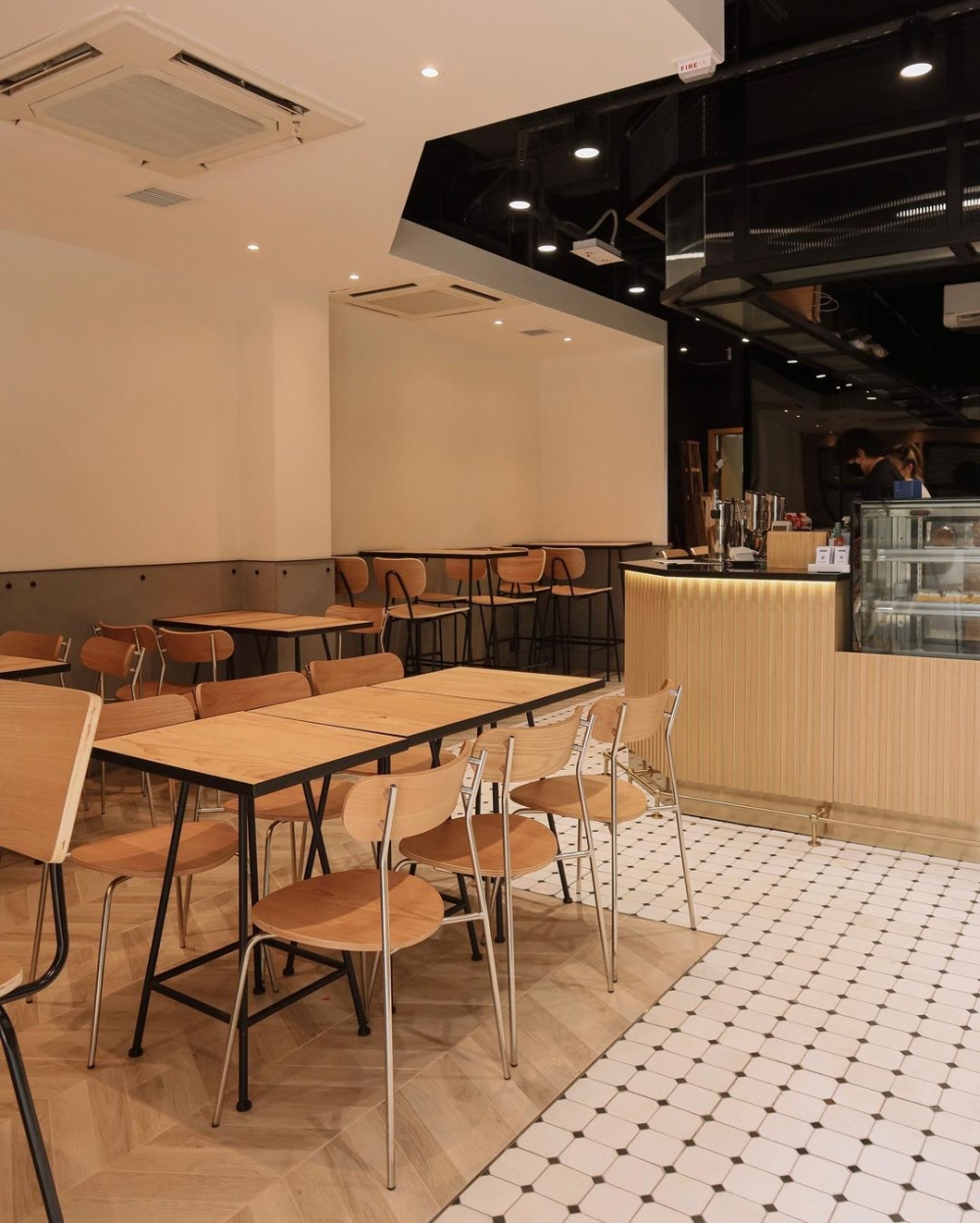 咖啡吧檯,木質桌椅,裝飾品與白色磁磚構出室內空間。