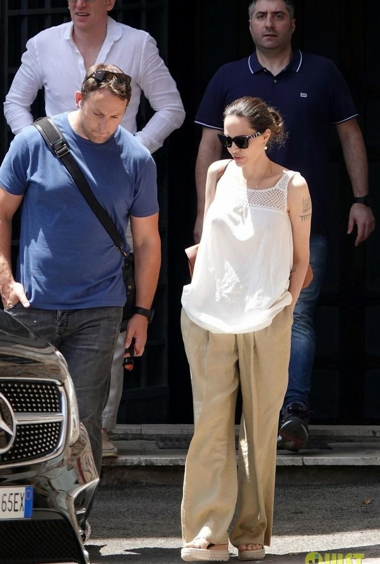 Angelina Jolie穿著一件白色背心與棕色寬長褲。