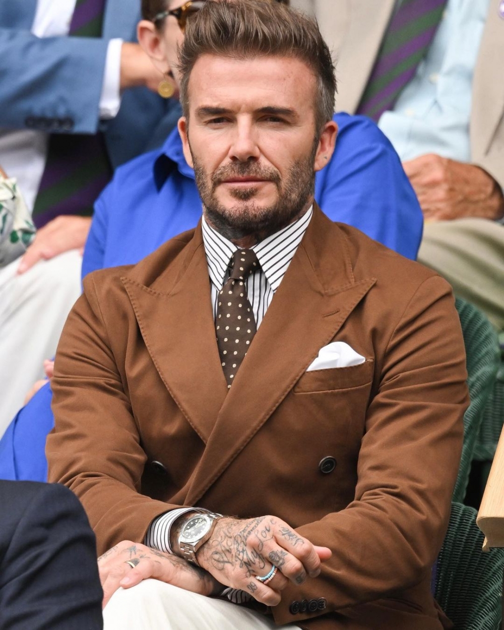 David Beckham穿著褐色西裝。