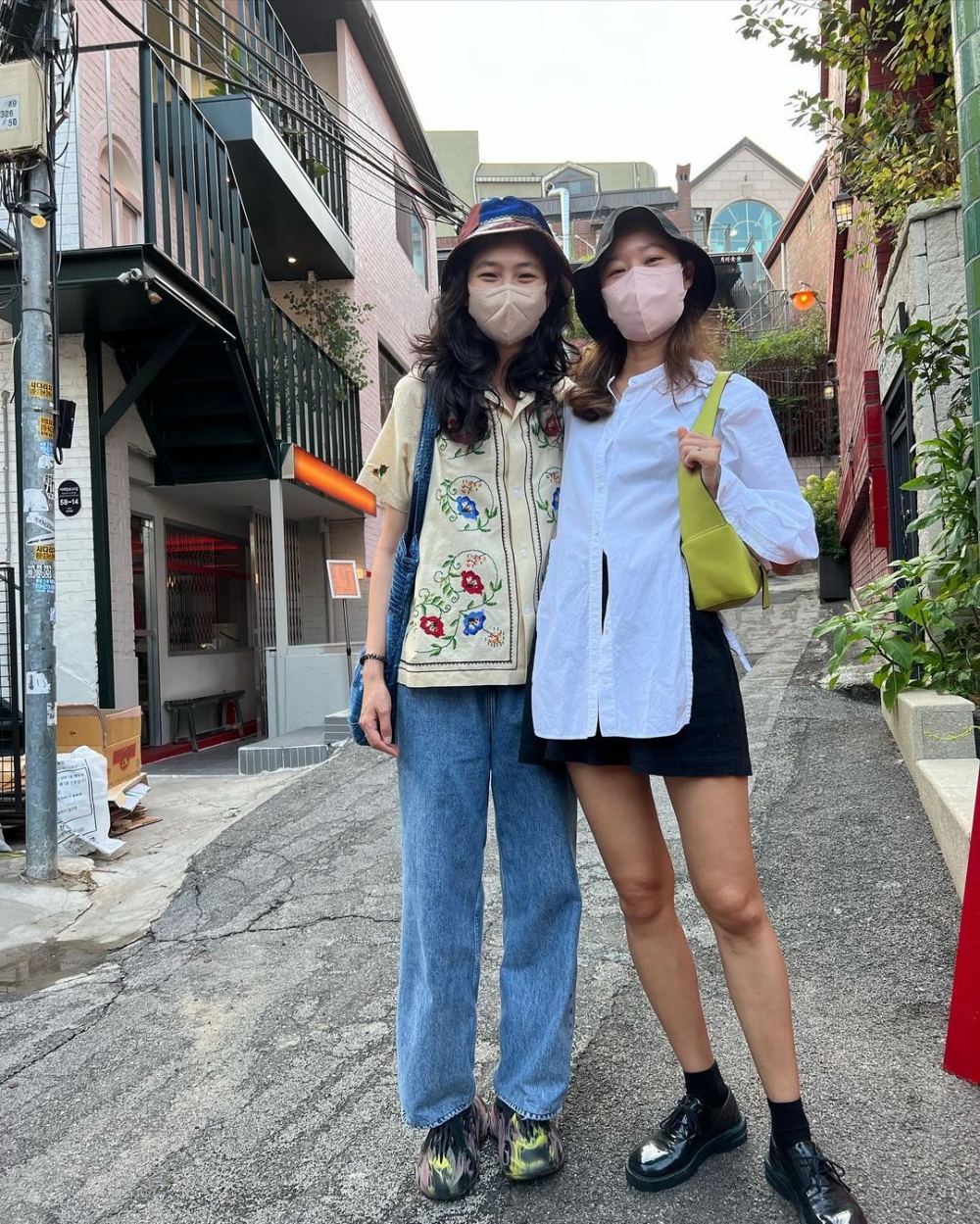 在黑白配的穿搭中與亮色系的手袋點綴。