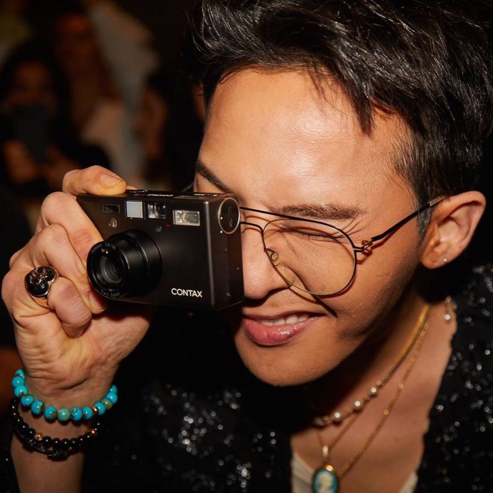 G-Dragon在活動上拿著相機拍攝畫面。