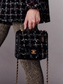 模特兒以手提方式詮釋細號手挽垂蓋手袋。