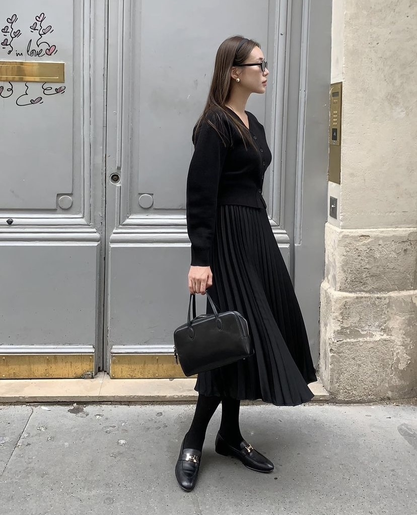 黑色針織衫配百褶裙。