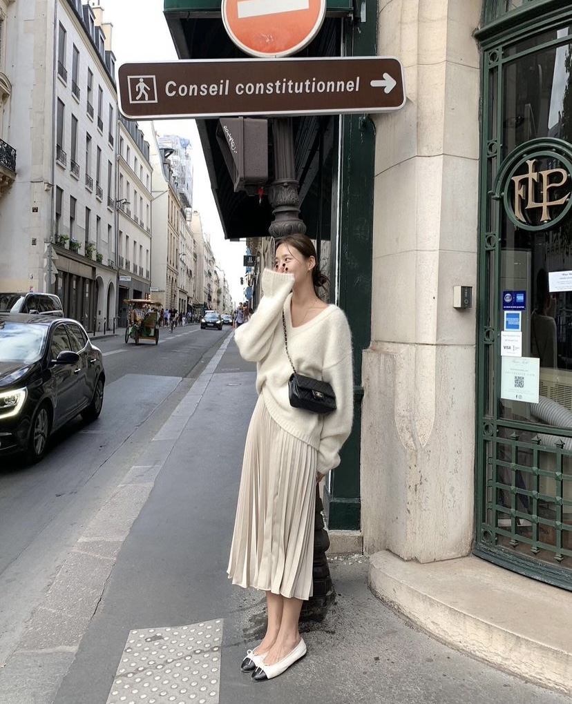 長版毛衣配同色系的百褶裙。