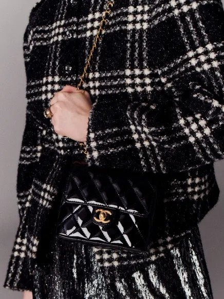 模特兒揹著漆皮小牛皮CHANEL Mini Flap Bag。