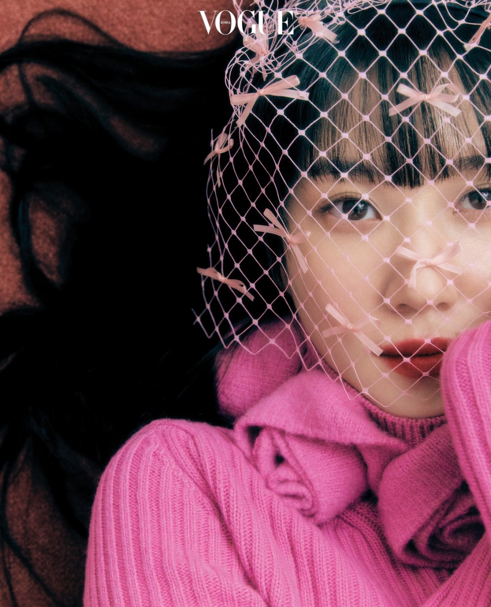 粉色高領針織連衣裙來自Blumarine,粉色網眼頭飾來自Q Millinery