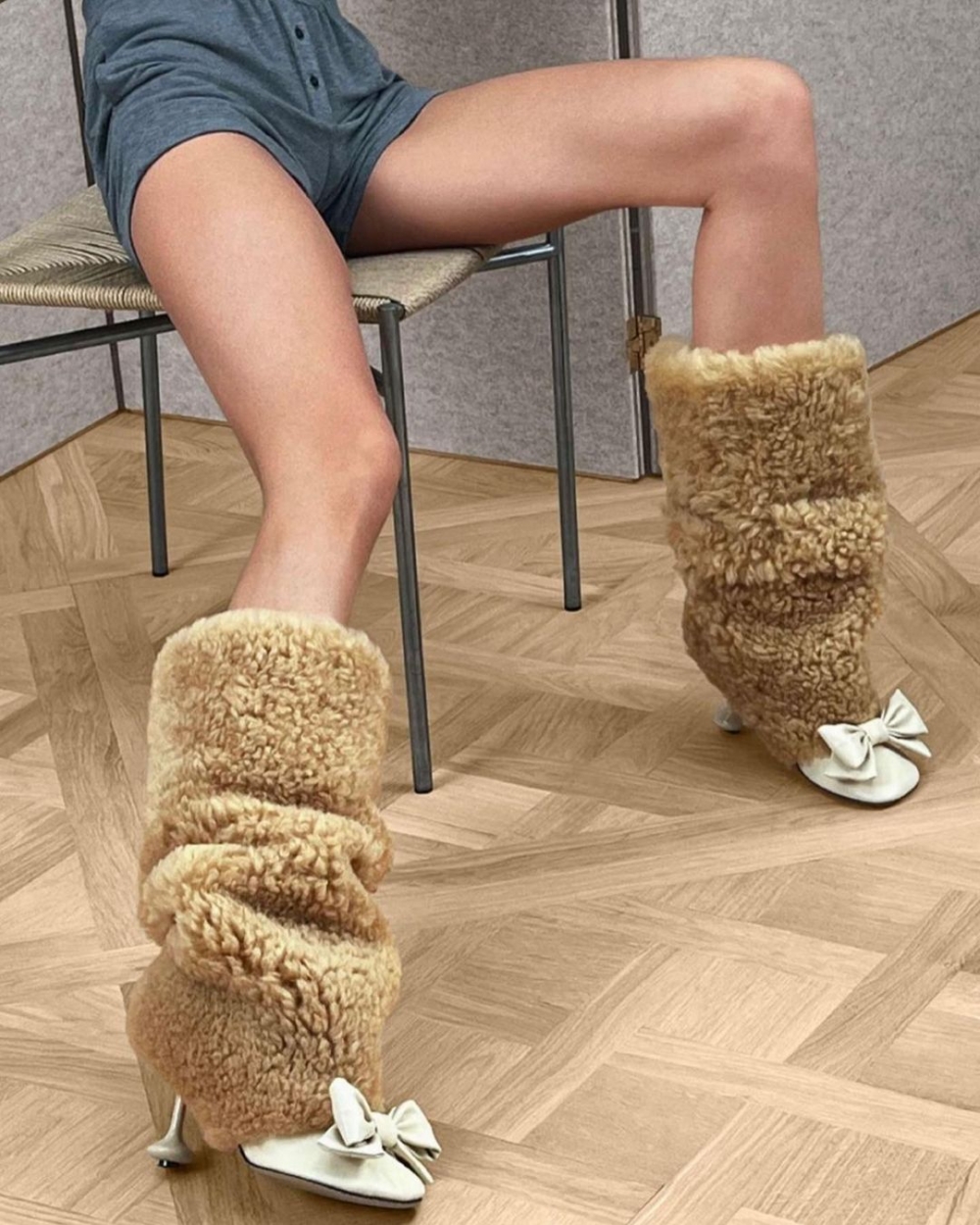 俏皮毛絨絨長靴在鞋頭點綴蝴蝶結。