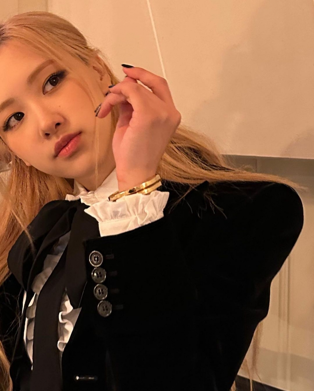 手腕間綴以荷葉邊,配戴金色珠寶配飾,展現了俐落又簡約的風格