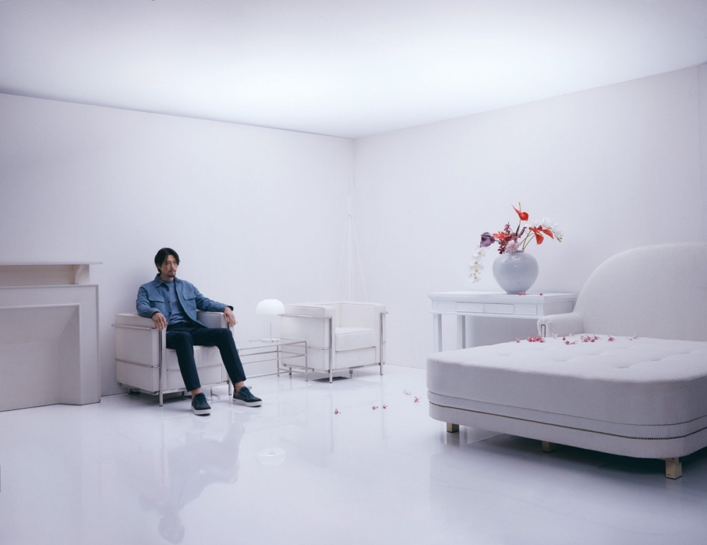 他坐在純白的房間裡，畫面十分藝術感。