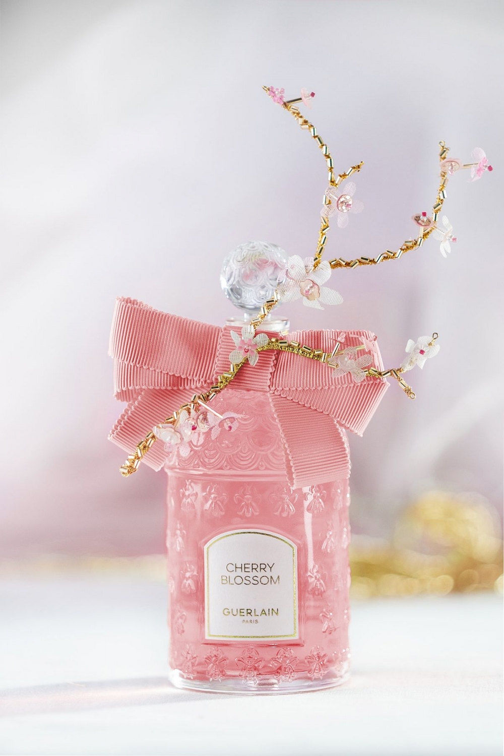 櫻花樹枝依偎在羅缎蝴蝶結上彷彿為蜂印瓶披上日本傳統雋永詩意