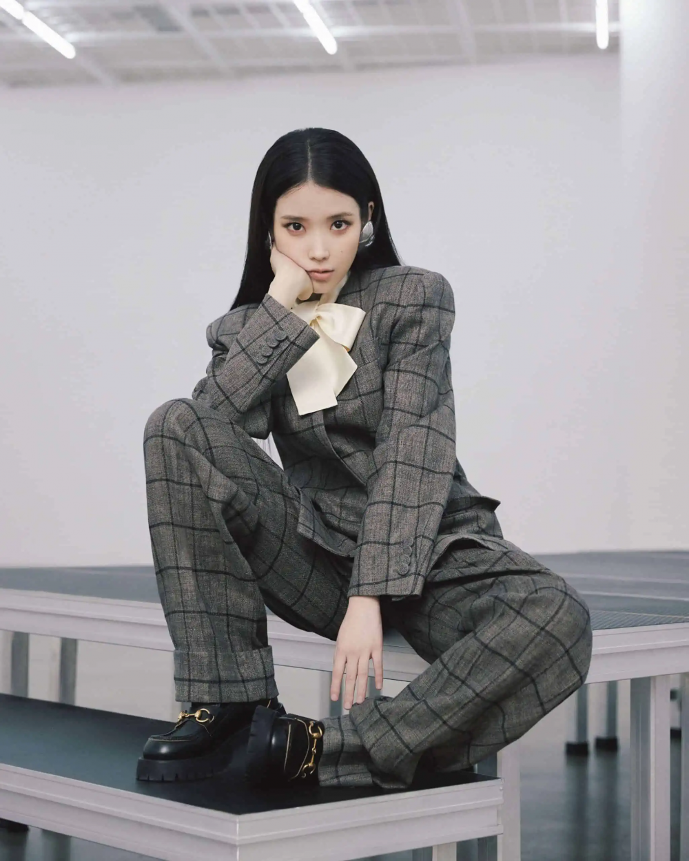 以一身中性的Gucci格紋墊肩西裝套裝與黑皮鞋現身