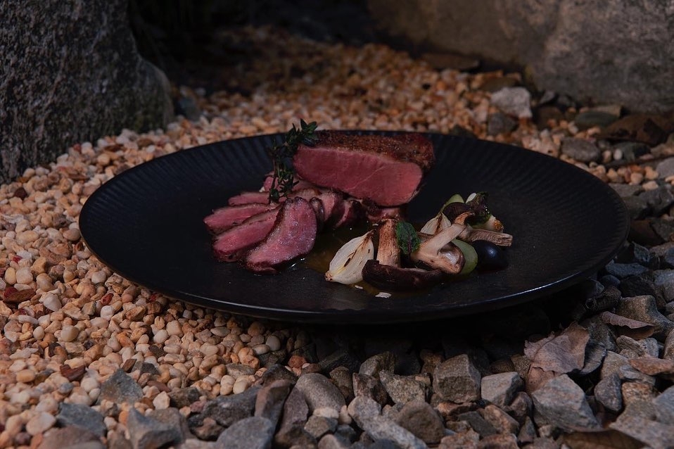 你能來品嚐餐廳烹煮的油封櫻桃鴨佐枯山円敷蜜柑橘醬。