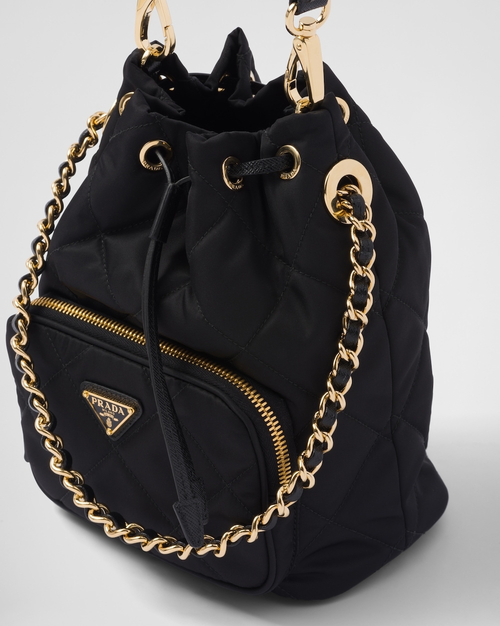 束口袋式的設計,最後拉鍊開合的口袋點綴飾塗琺瑯金屬三角形徽標