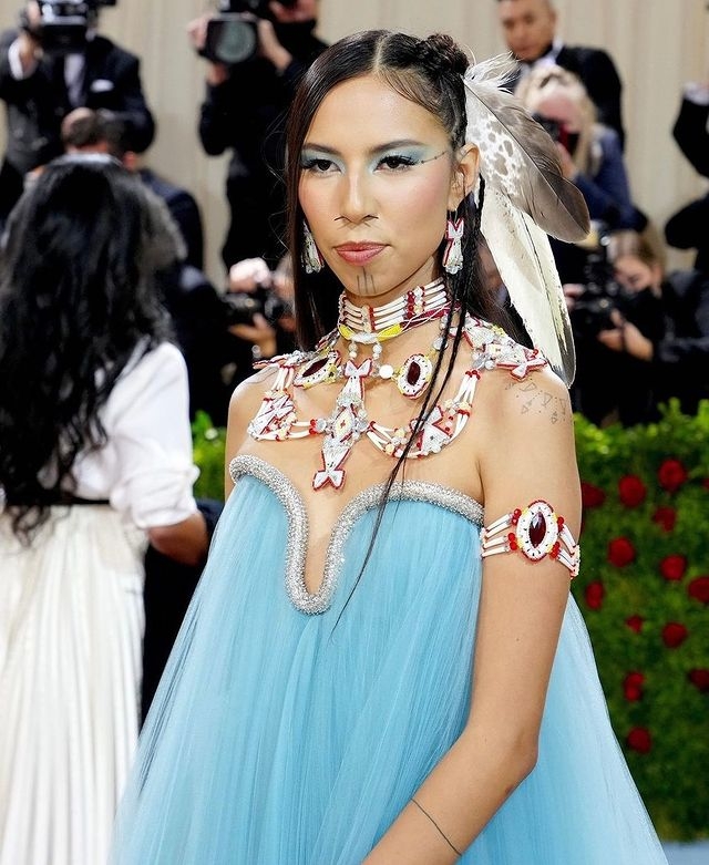 精緻的珠寶採用動物犬齒、貝殼、豪豬刺和珠子彰顯她美洲原住民的身份。