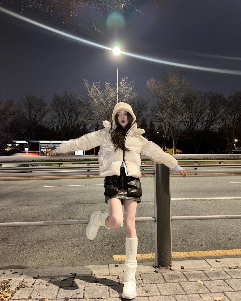 亮面羽絨服搭配同色調的長襪以及保暖長靴