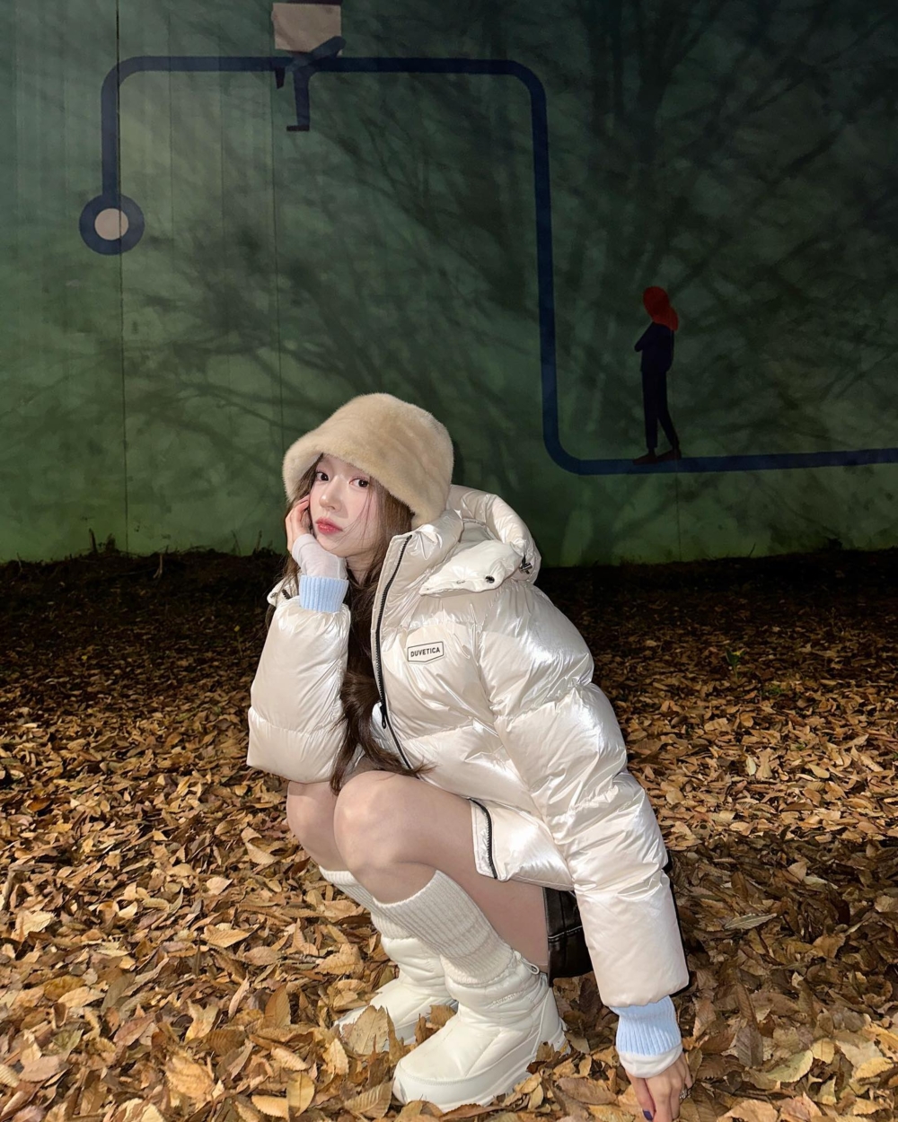 亮面羽絨服搭配同色調的長襪以及保暖長靴