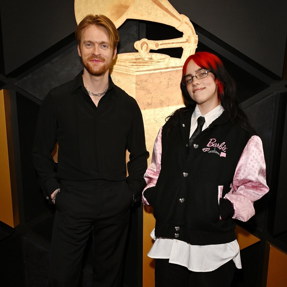 Billie Eilish以一頭紅黑色頭髮，搭配黑粉色芭比校服夾克出席紅毯