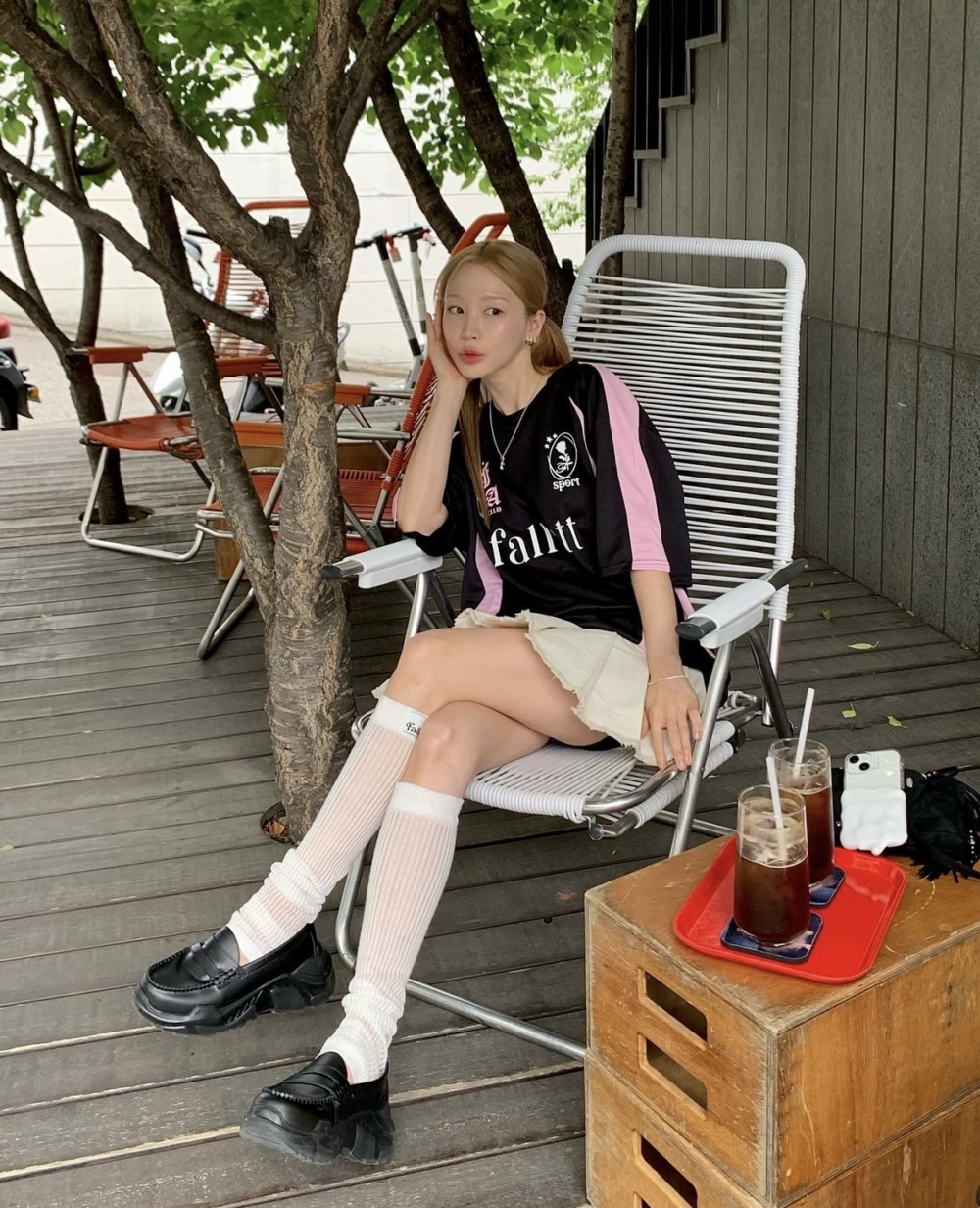 以寬鬆的上衣搭配短版的牛仔裙。