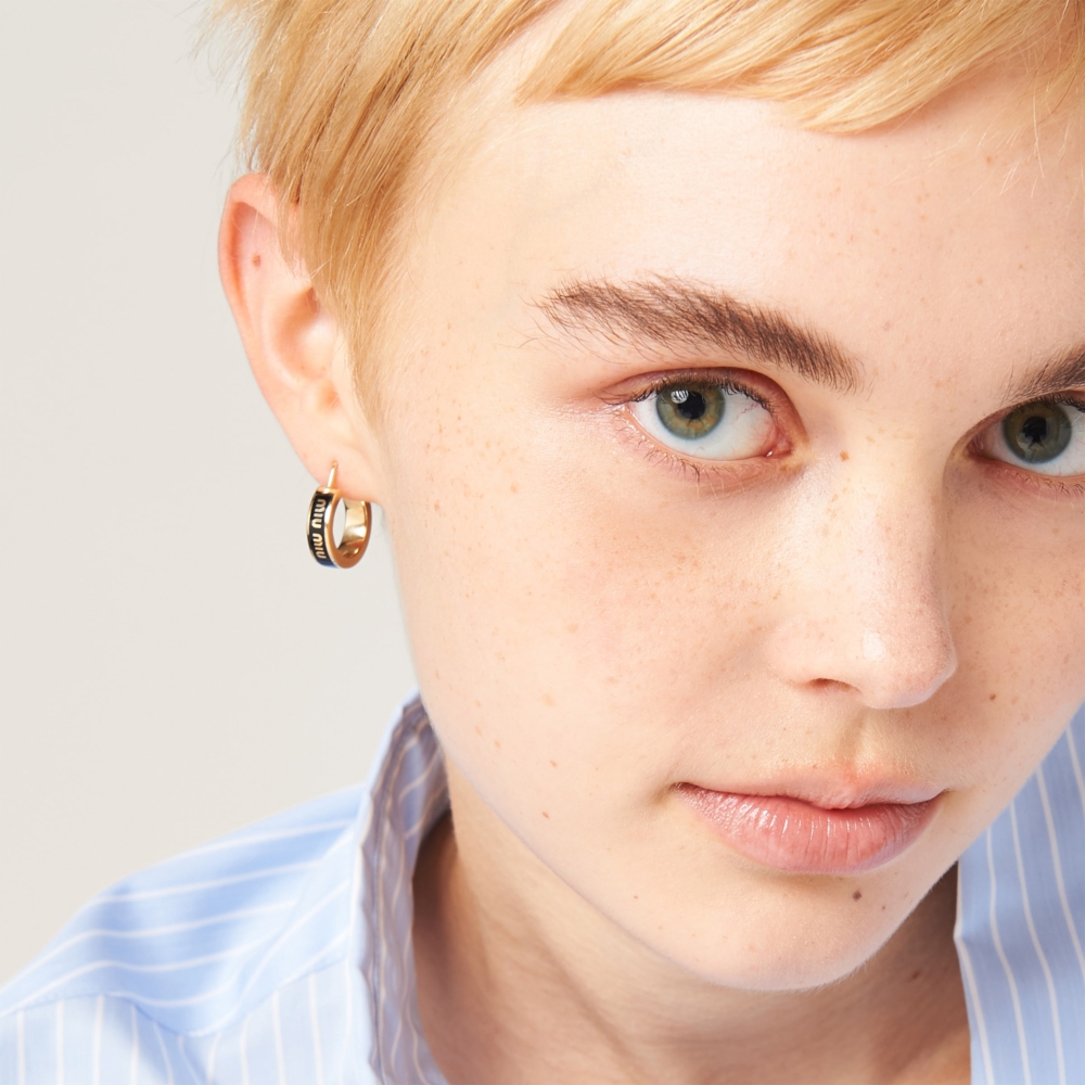 模特兒詮釋Enameled metal earrings。
