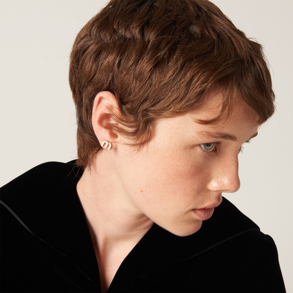 模特兒詮釋Enameled metal earrings。