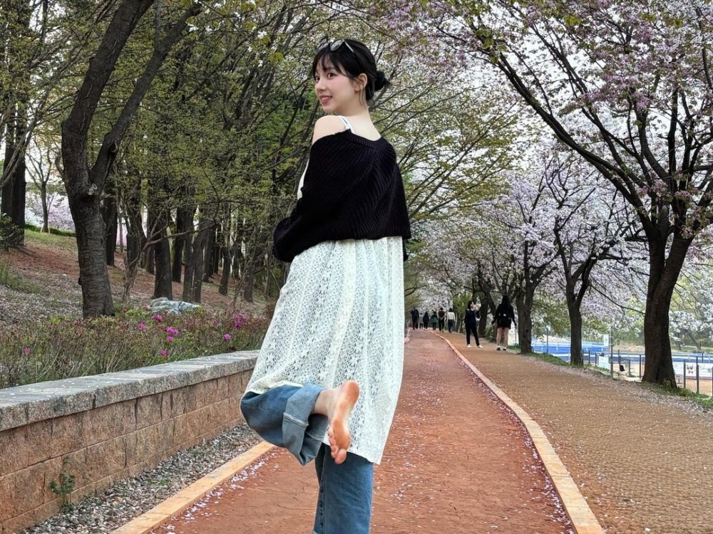 Karina穿上白色洋裝搭配牛仔褲，青春洋溢