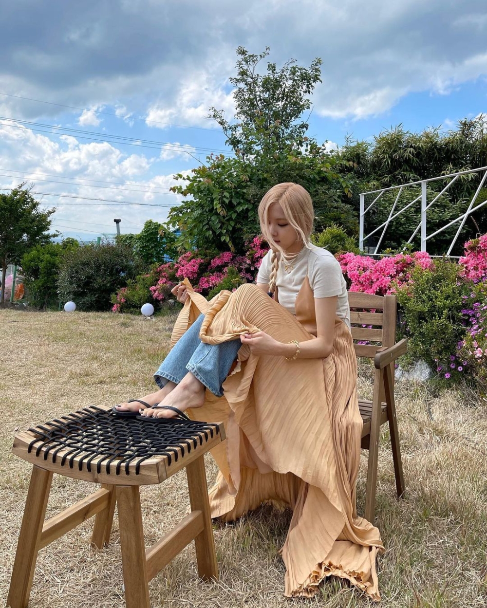 ROSÉ穿上粉橘色細百摺洋裝搭配牛仔褲，顯得更有氣質