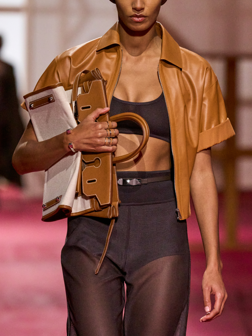 秀場上模特兒大多將手袋折疊抱在身上，也讓我們想到Flat Kelly可折疊綁帶的設計