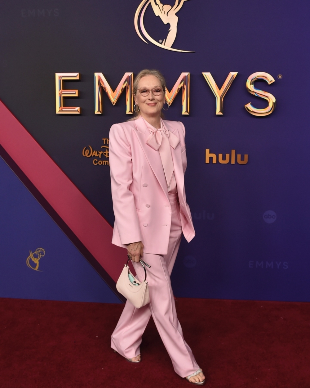 Meryl Streep穿著一套帶有蝴蝶結襯衫的長褲套裝。