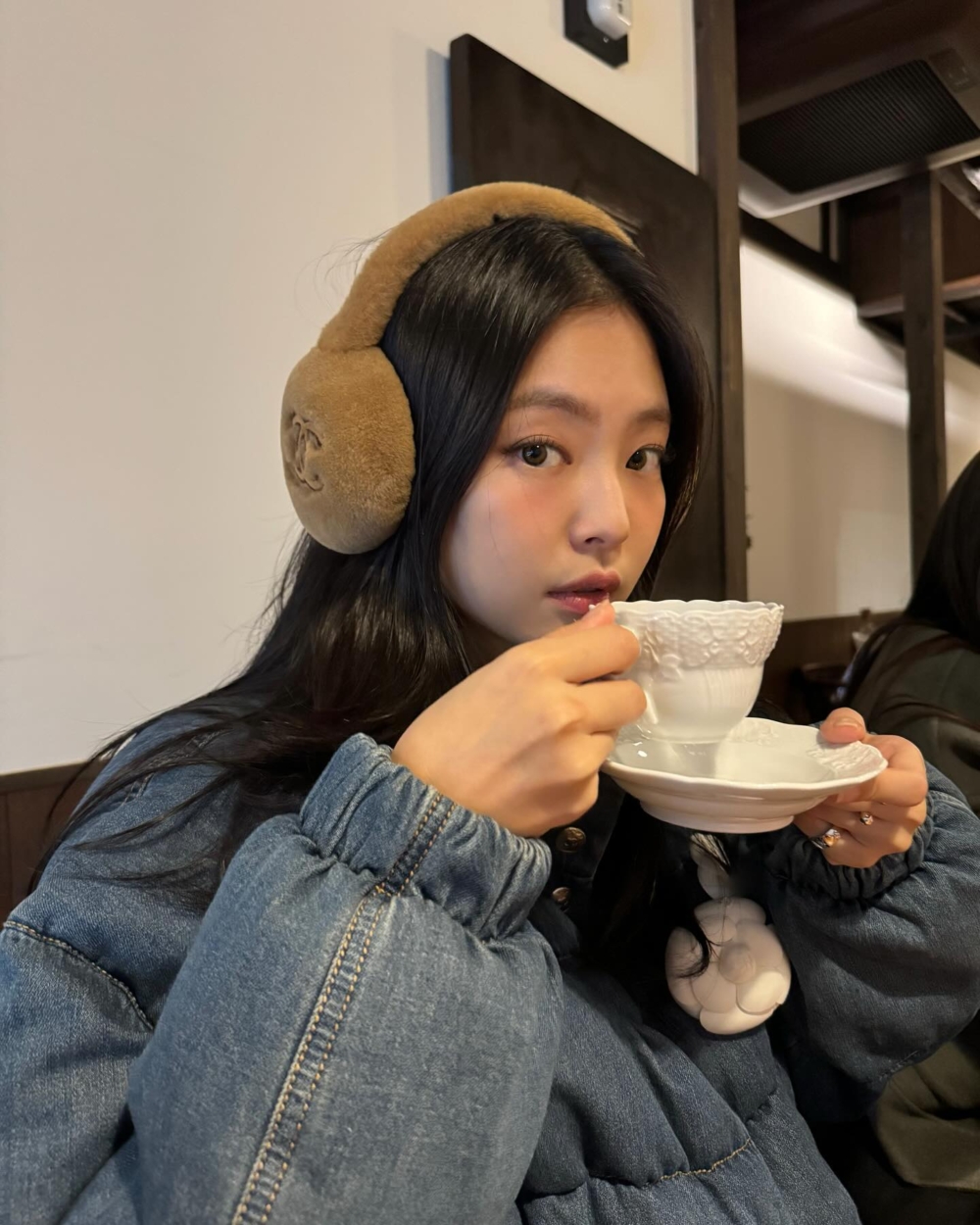 Jennie的整趟旅程中,一款棕色毛絨絨的耳罩出鏡率極高