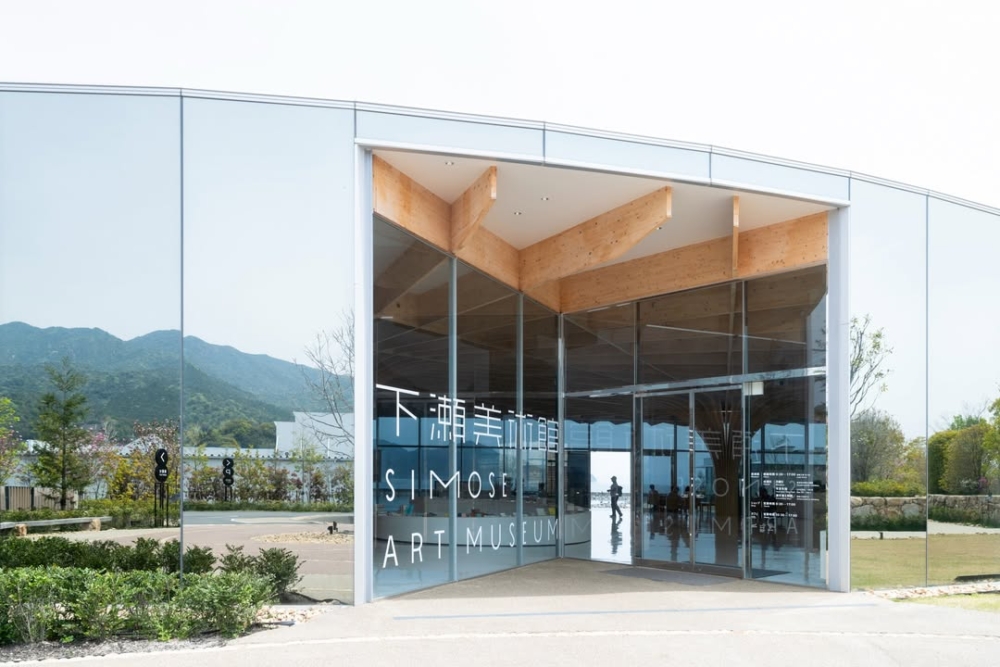 主建築的玻璃立方體矗立在瀨戶內海旁，與周圍的森林、山水融為一體