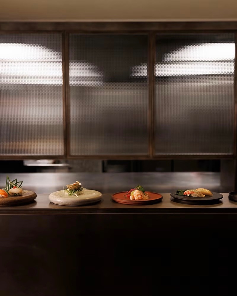 桌上特製的深色餐盤陶瓷器皿，更賦予了這個空間一種侘寂的氛圍