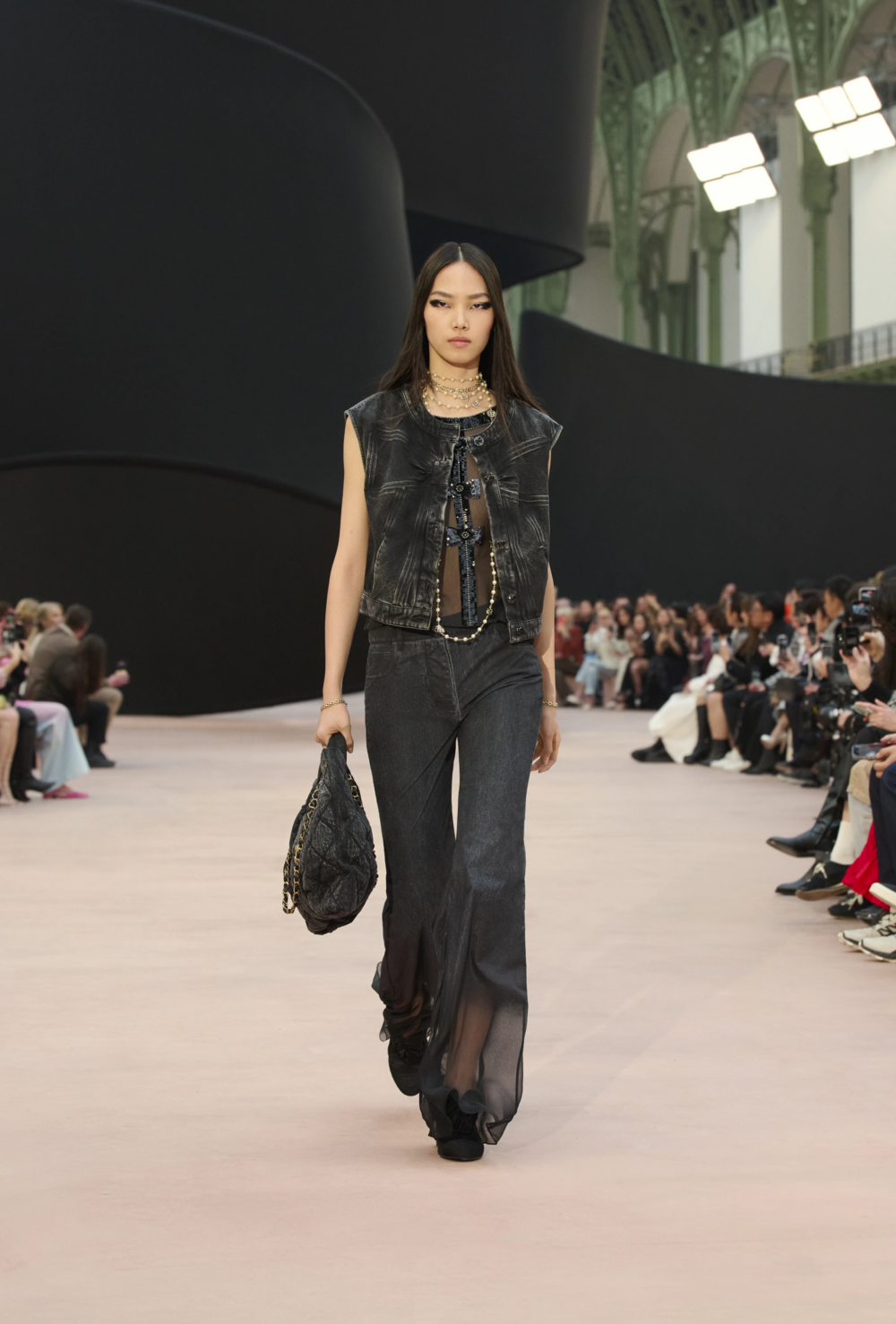 以黑色洗舊牛仔布製成，保留菱格紋與雙C logo，搭配金屬鏈條