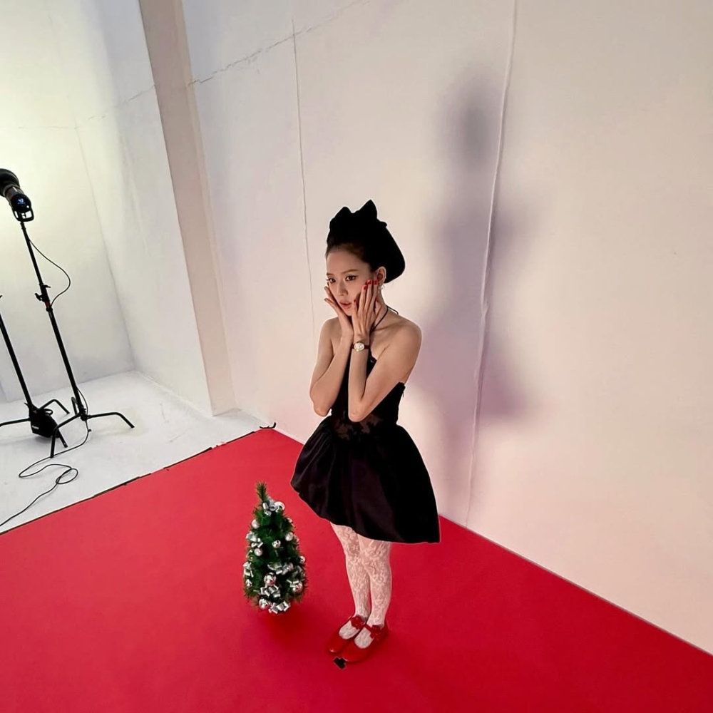頭上以黑色蝴蝶結紮起的包頭,更呼應了整體復古甜美的氛圍