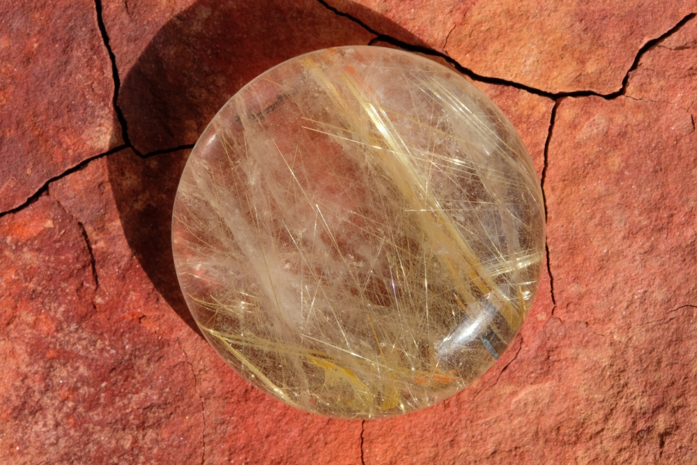 金鈦晶裡的金紅石針絲更粗壯且排列更具層次，所以價錢也更高