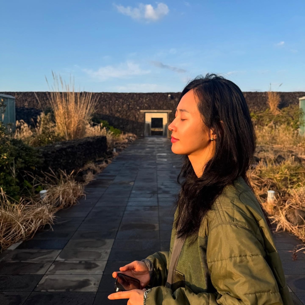 頻頻在Instagram上傳濟州島的日常剪影:湛藍的天空下,暖陽灑在碧綠草地,她赤腳漫步沙灘