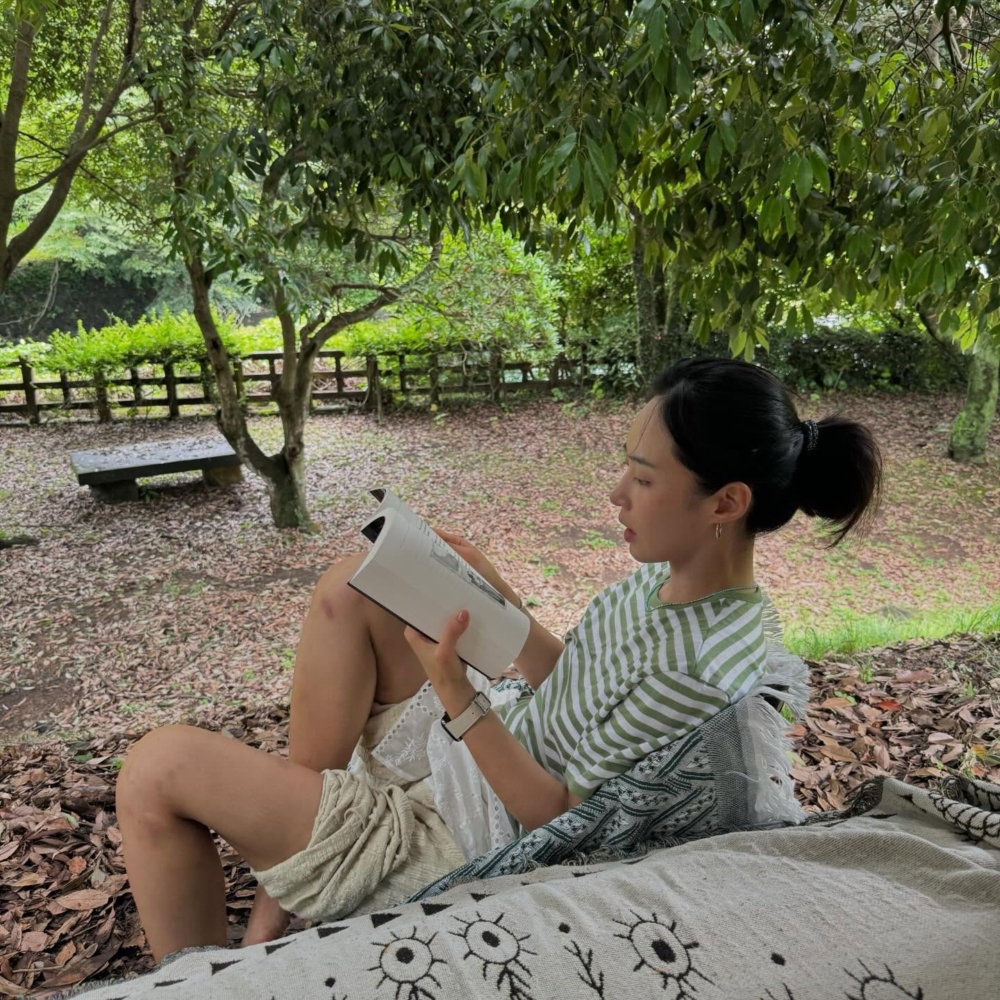 手捧咖啡坐在陽光灑落的窗台旁。那畫面乾淨得像一首詩