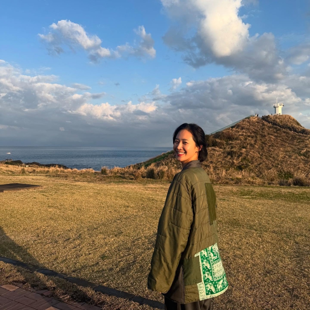 頻頻在Instagram上傳濟州島的日常剪影:湛藍的天空下,暖陽灑在碧綠草地,她赤腳漫步沙灘