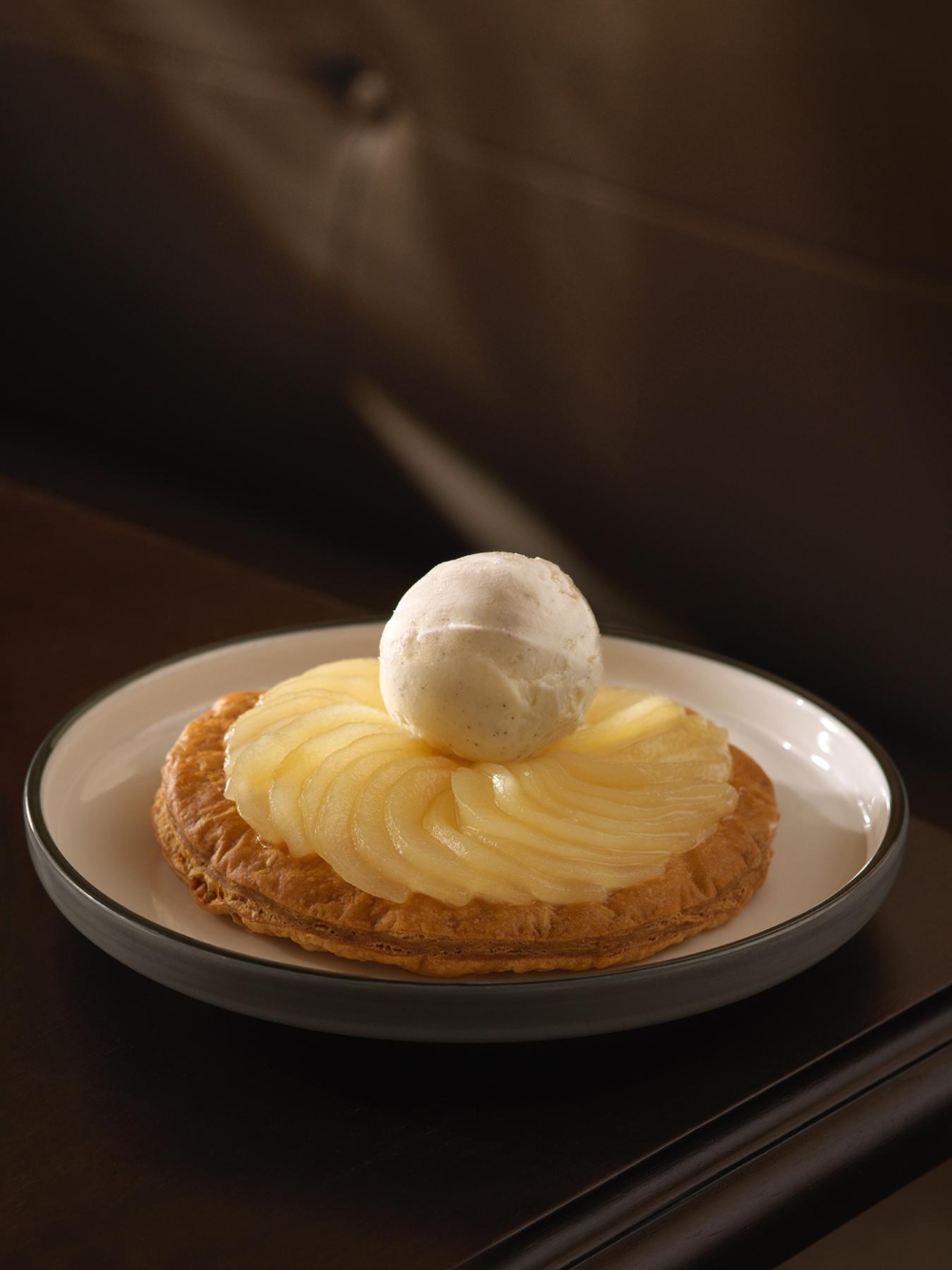 Roland 招牌梨子撻配自製雲尼拿意式雪糕，酥薄酥化的塔皮承載法國梨的鮮甜多汁，搭配緩緩融化的自製雲尼拿意式雪糕，冷熱交織，呈現細膩優雅的甜點風味。