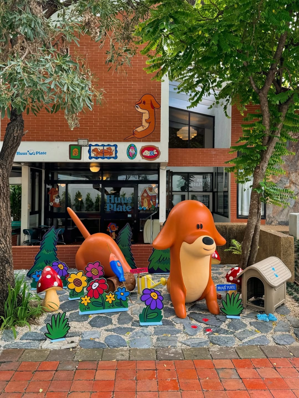 遠遠的就可以看到店門口一隻躺在紅磚上的臘腸狗雕像