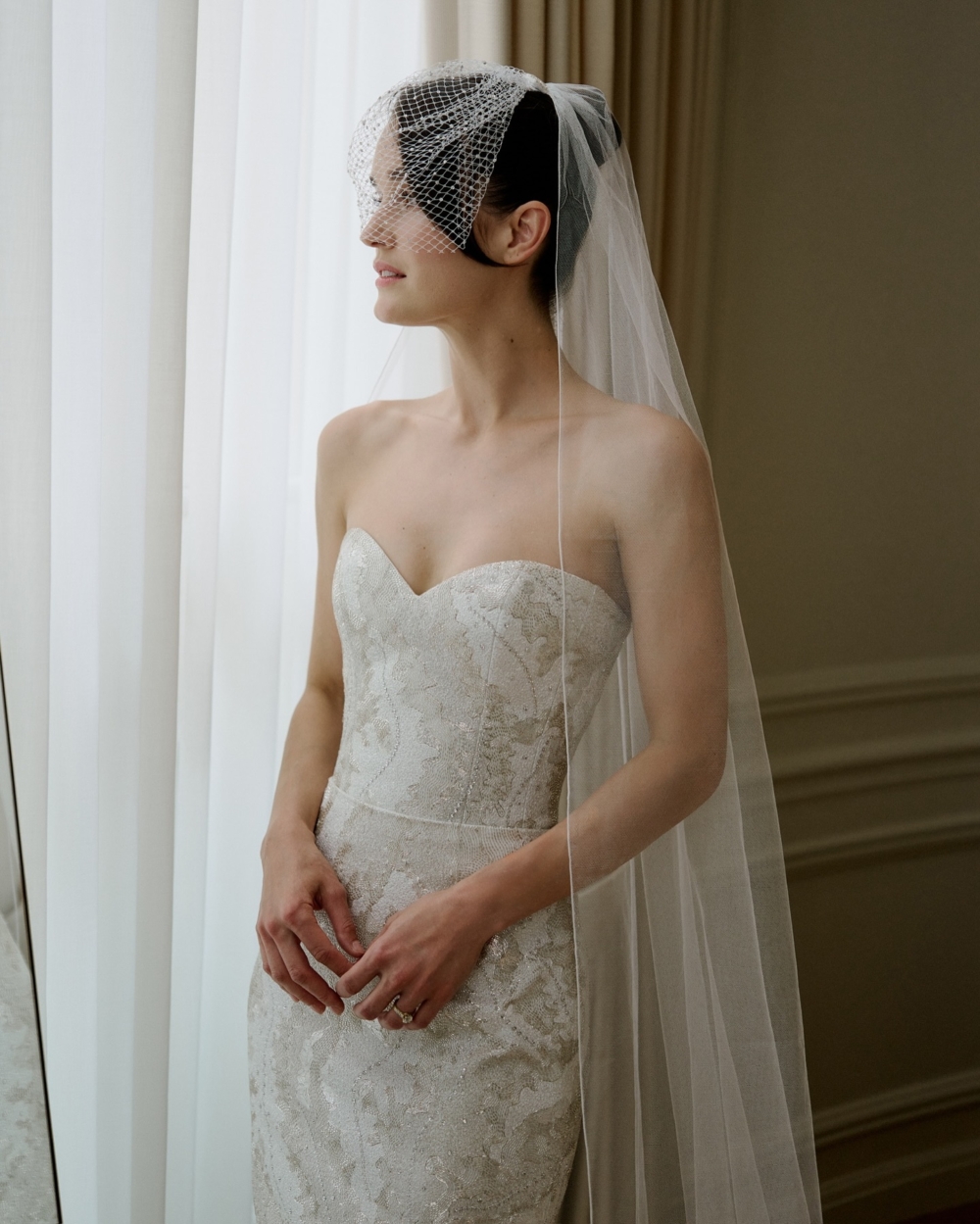 Kate 則身著白色刺繡束胸與飄逸裙襬，配上精緻的鳥籠面紗