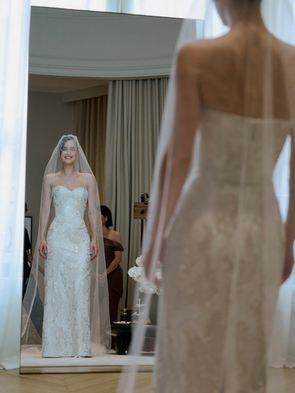 Kate 則身著白色刺繡束胸與飄逸裙襬，配上精緻的鳥籠面紗