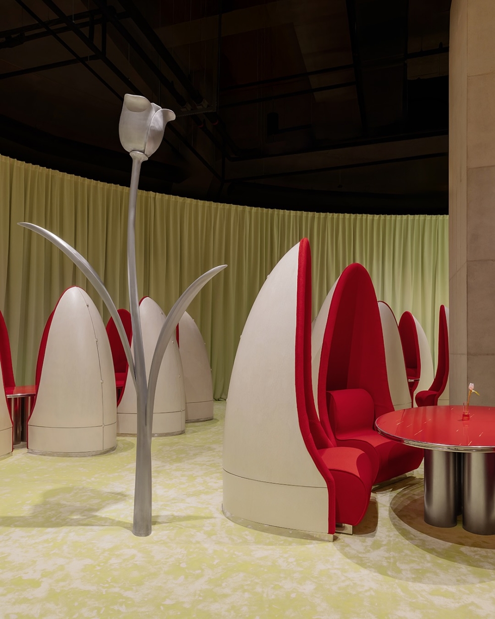 紅白蛋形椅，加上深紫色的沙發空間，搭配黃綠色布簾，打造溫潤、怪奇卻迷人的精緻場域