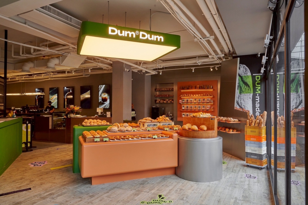 踏入空間，設計師在 Phase Coffee 標誌性的沈穩大地色系中，大膽注入了 DUM DUM 充滿活力的品牌綠。